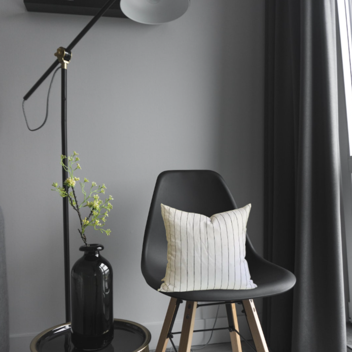 Black and white striped linen pillow on black chair