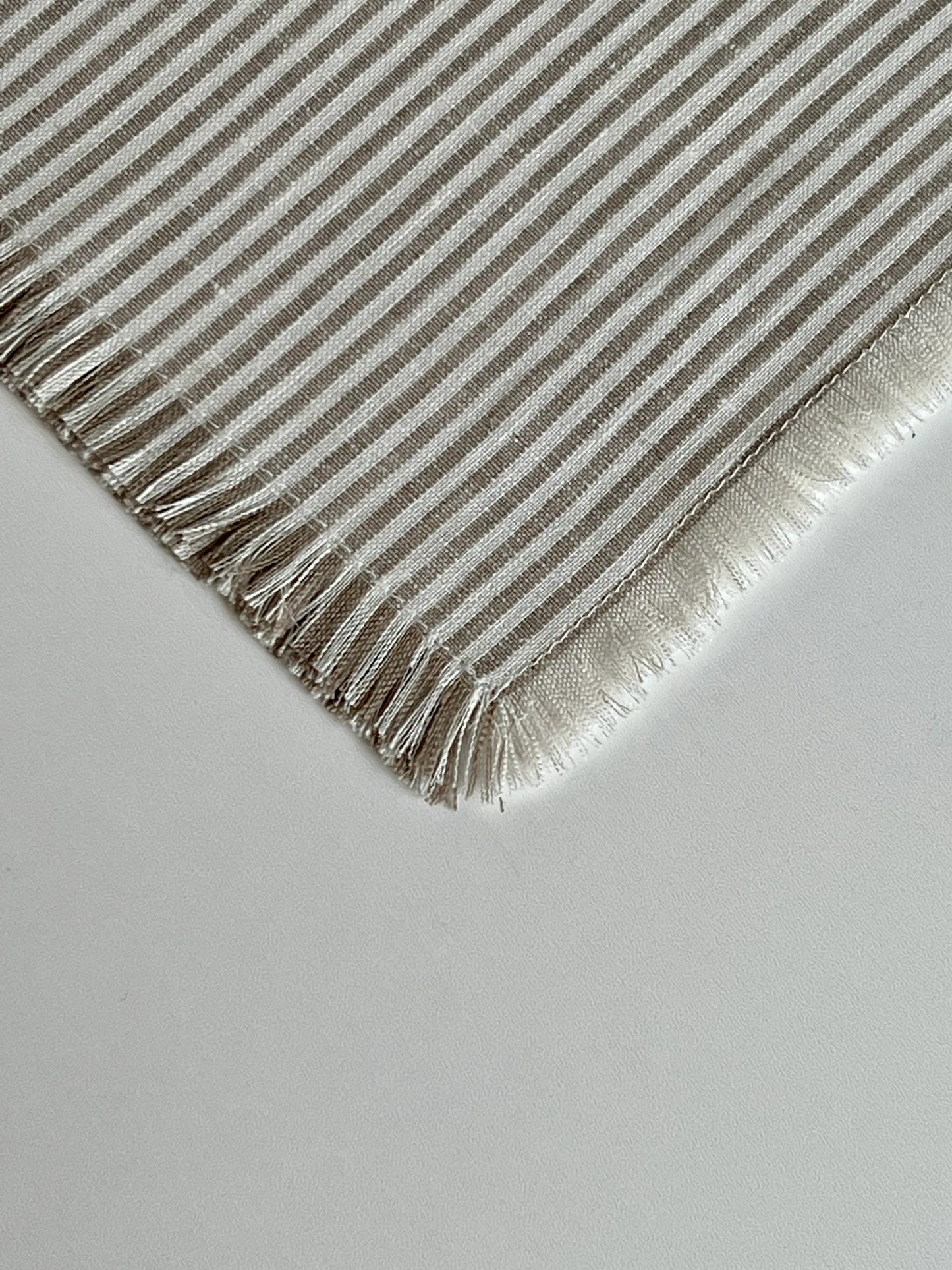 Beautifully crafted in Oeko-Tex linen, these soft beige and white napkins have subtle thin stripes and fringed edges. Perfect for fancy or fuss free tables, these napkins are sustainable, absorbent, lint free and gorgeous! 100% linen Size is 19x19" Designed and made in Canada. Machine washable