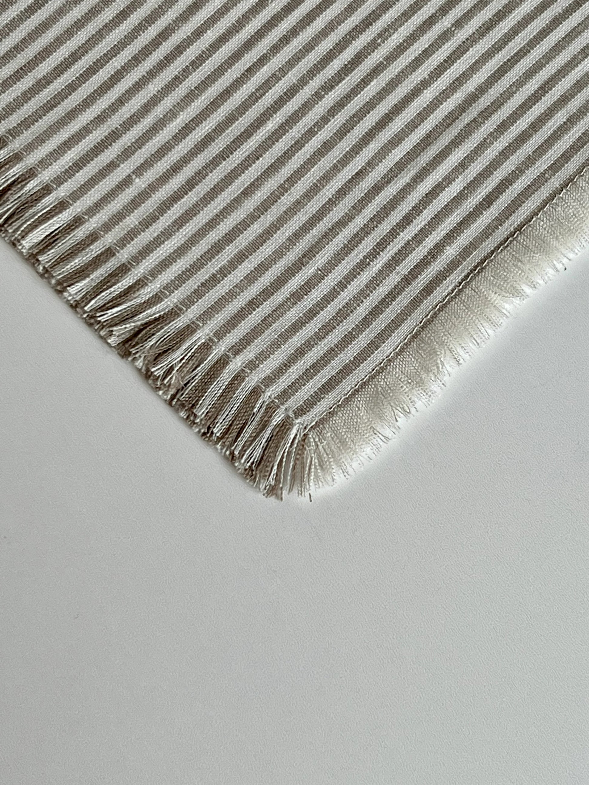 Beautifully crafted in Oeko-Tex linen, these soft beige and white napkins have subtle thin stripes and fringed edges. Perfect for fancy or fuss free tables, these napkins are sustainable, absorbent, lint free and gorgeous! 100% linen Size is 19x19" Designed and made in Canada. Machine washable