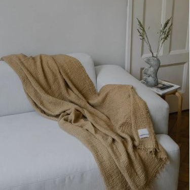 Rich chestnut coloured Stonewashed European linen throw draped over sofa