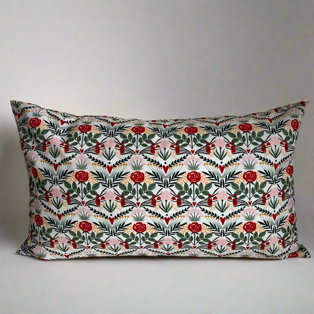 sweet hearts and flowers organic cotton Love lumbar pillow.  Made with love in Canada, this whimsical pillow adds a touch of fun and comfort! Just the right size to tuck under your neck, it is oh-so-soft and perfect for reading or napping. 10 x 18 inch