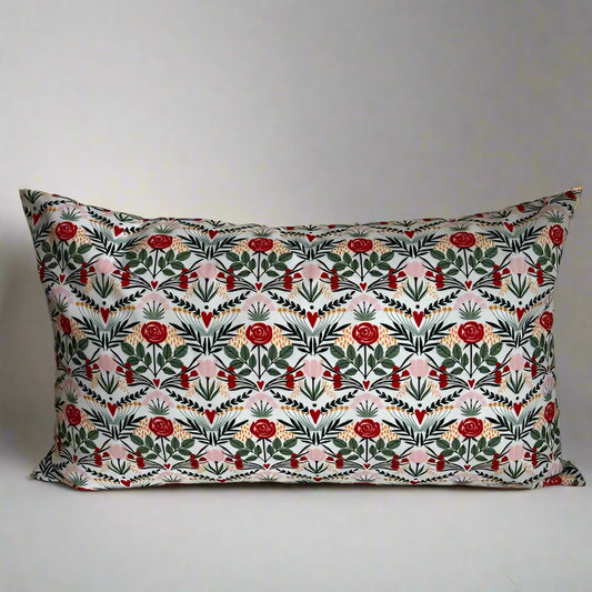 sweet hearts and flowers organic cotton Love lumbar pillow.  Made with love in Canada, this whimsical pillow adds a touch of fun and comfort! Just the right size to tuck under your neck, it is oh-so-soft and perfect for reading or napping. 10 x 18 inch