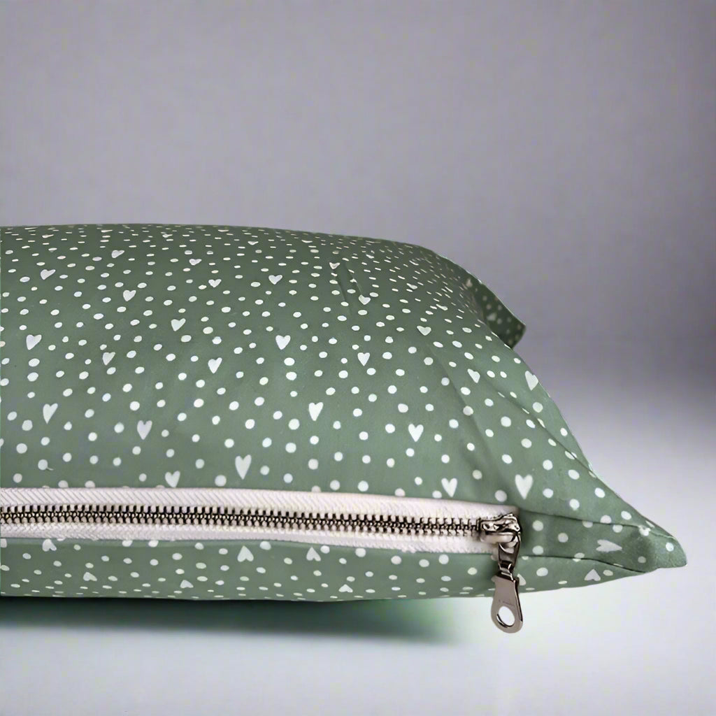 Show you care with this beautiful flowers and hearts organic cotton lumbar pillow.  Made with love in Canada, this whimsical pillow adds a touch of summer and comfort! Just the right size to tuck behind your neck, it is oh-so-soft and perfect for reading or napping. 10 x 18 inches with white exposed zipper.