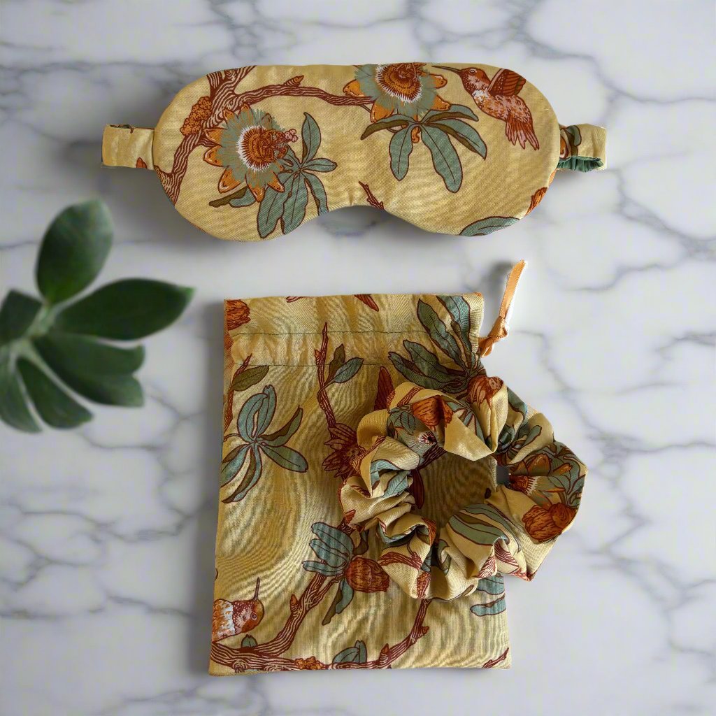 The Sleep Mask and Scrunchie Gift Set features a comfy, eco-friendly design made from organic cotton and adorned with a beautiful hummingbird and floral pattern. Made with soft layers of cotton batting, this sleep mask offers a dreamy night's rest. Plus, it comes with a matching scrunchie and convenient carry bag for your glasses or favorite aromatherapy. Upgrade your sleeping experience and indulge in the luxurious comfort of this gift set!