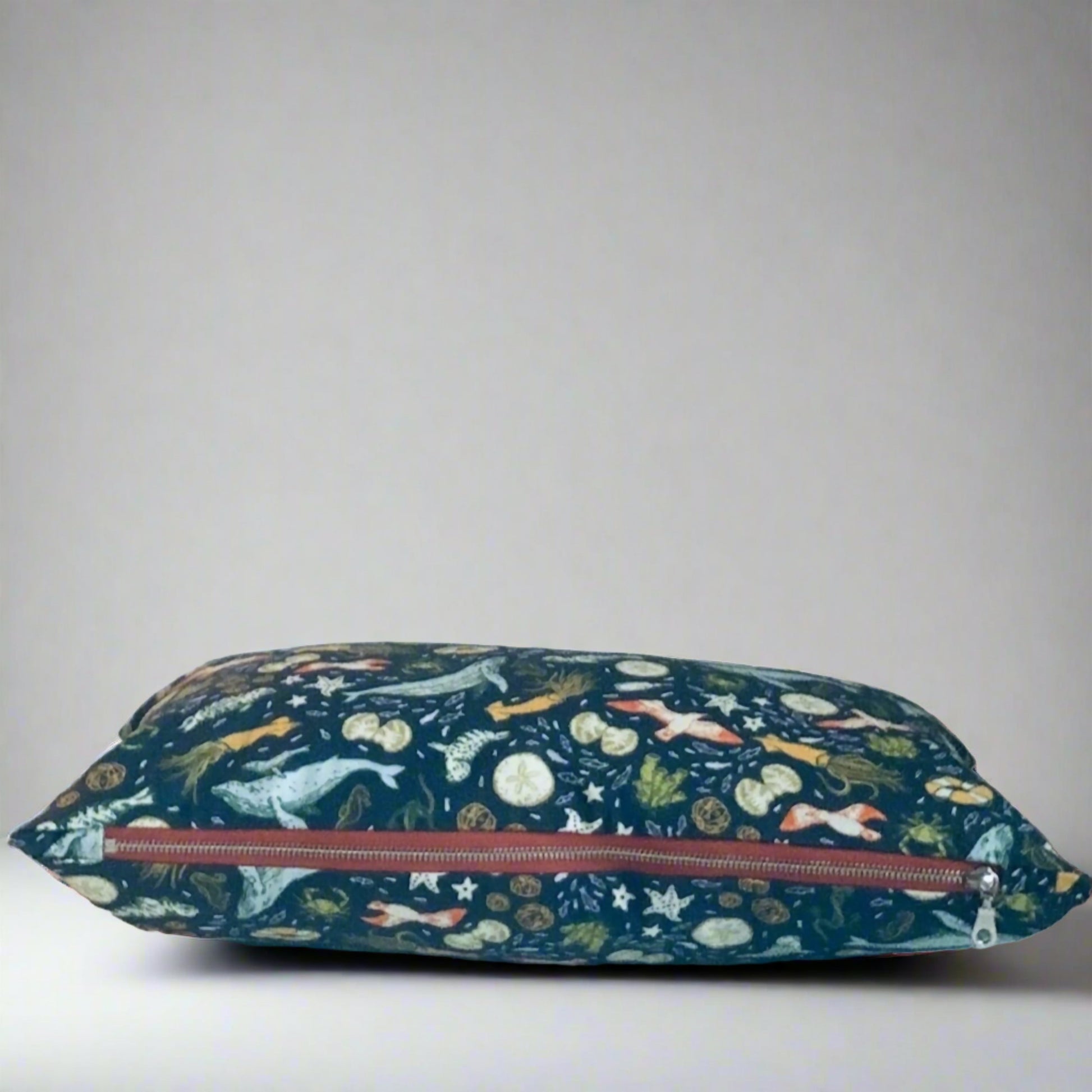 This soft organic cotton pillow cover depicts the diverse marine life off the B.C. Pacific coast. This pillow has an exposed, terracotta coloured zipper that contrasts beautifully with shades of blue and pops of orange and sea green. A beautiful accent in any home or cottage.  100% Organic Cotton, handmade in Canada.  Size 14" x 20"   Machine wash warm, low heat dryer  Made to order. 