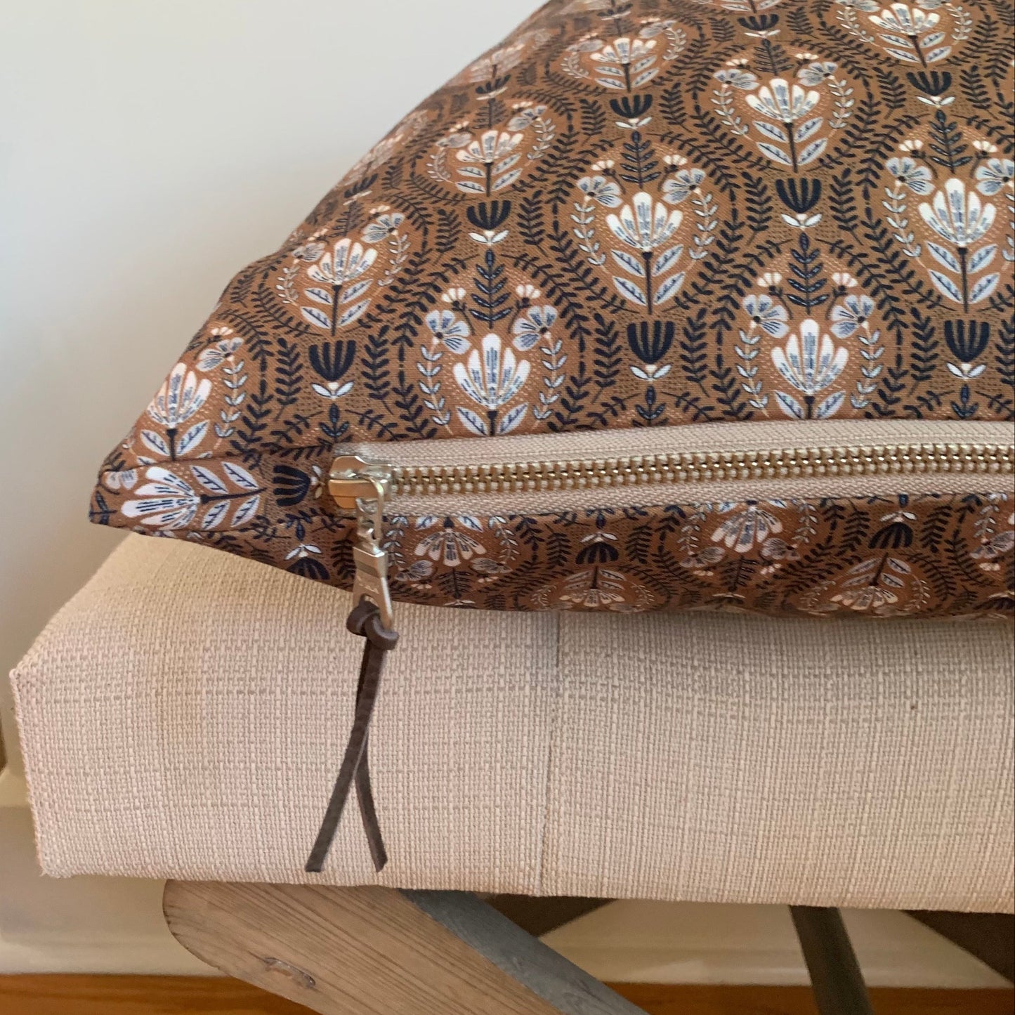 Organic cotton small floral pattern pillow with cream exposed zipper.