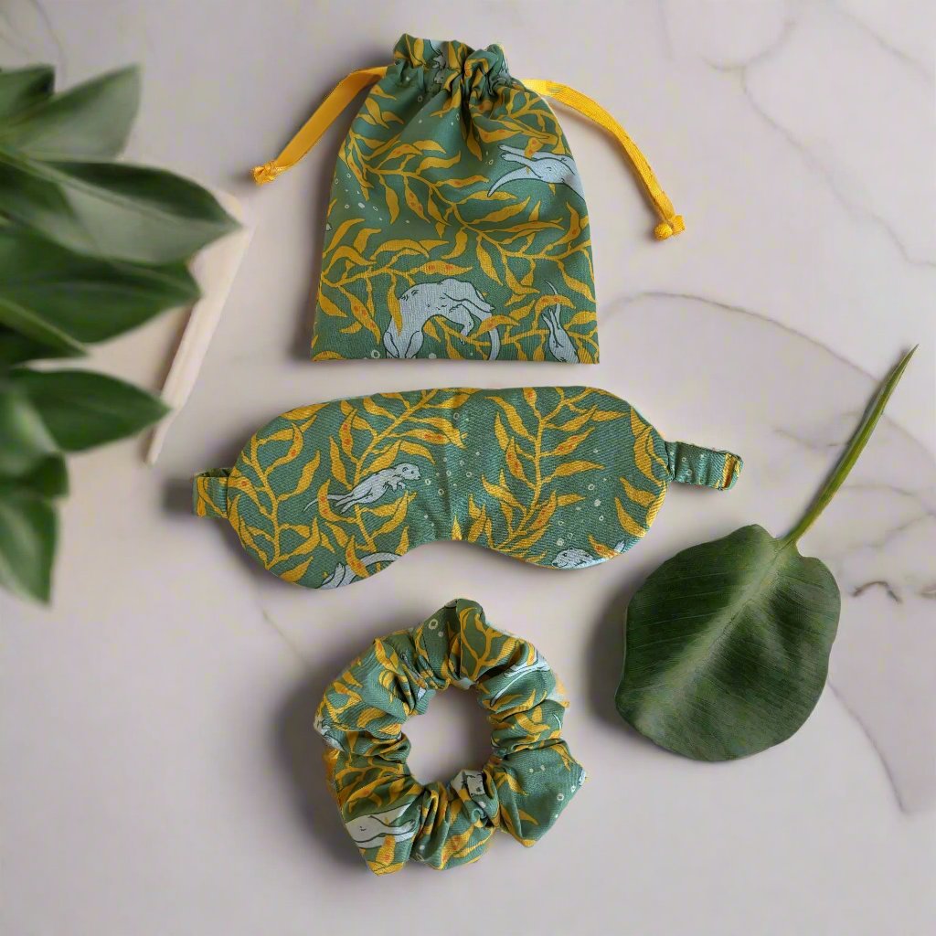 The Sleep Mask and Scrunchie Gift Set features a comfy, eco-friendly design made from organic cotton and adorned with a playful Sea Otter or luxurious dark grey velvet. Made with soft layers of cotton batting, this sleep mask offers a dreamy night's rest. Plus, it comes with a matching scrunchie and convenient carry bag for your glasses or favorite aromatherapy. Upgrade your sleeping experience and indulge in the luxurious comfort of this gift set!
