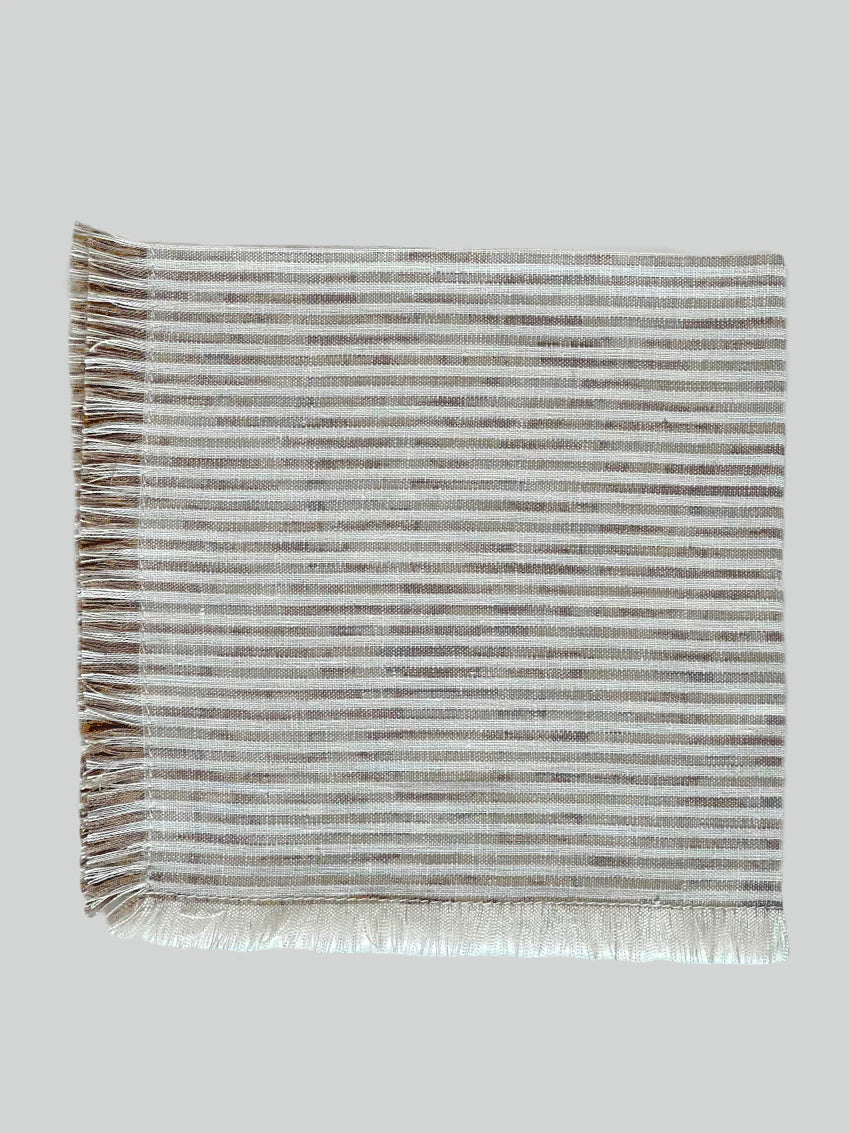 Beautifully crafted in Oeko-Tex linen, these soft beige and white  napkins have subtle thin stripes and fringed edges. Perfect for fancy or fuss free tables, these napkins are sustainable, absorbent, lint free and gorgeous! 100% linen Size is 19x19" Designed and made in Canada. Machine washable