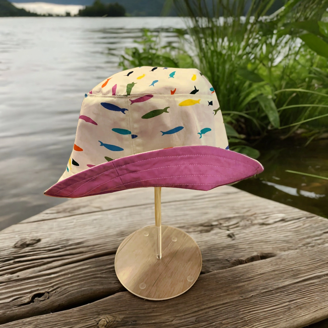 stylish Organic Cotton Rainbow Minnow Bucket Hat! Perfect for brightening up your style with its soft and comfy organic cotton fabric and reversible lining in a range of fun colours, pink, navy, sage green and cottage blue.