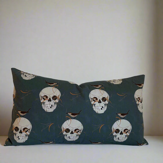 Have fun with your Halloween decor with this playful organic cotton pillow featuring Charlie Harper's spooky Skull and Wren design. The exposed white zipper adds a unique touch against the skulls on a dark grey background. Handcrafted in Canada, this pillow is sure to add some spooktacular charm to your home.

Size 12" x 20" - Down alternative insert with 100% cotton cover included