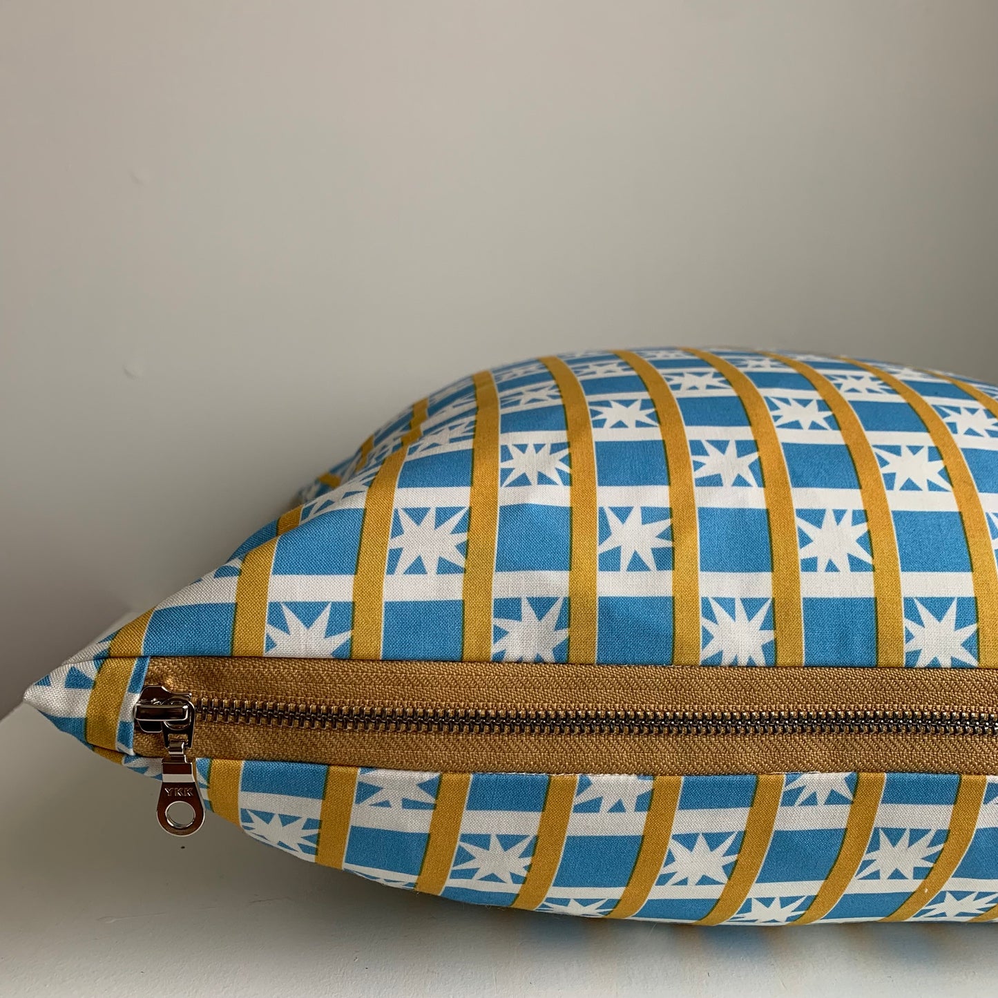 Handcrafted in Canada, this lovely cottage blue with white starburst fabric is gorgeous! Made from GOTS certified organic cotton. It's soft to the touch with an exposed mustard coloured zipper adding a another pop of colour to this beautiful fabric. Add a retro touch&nbsp; to your home, cottage, bunkie, or sunroom. Sizes 18 x 18 and 12 x 20