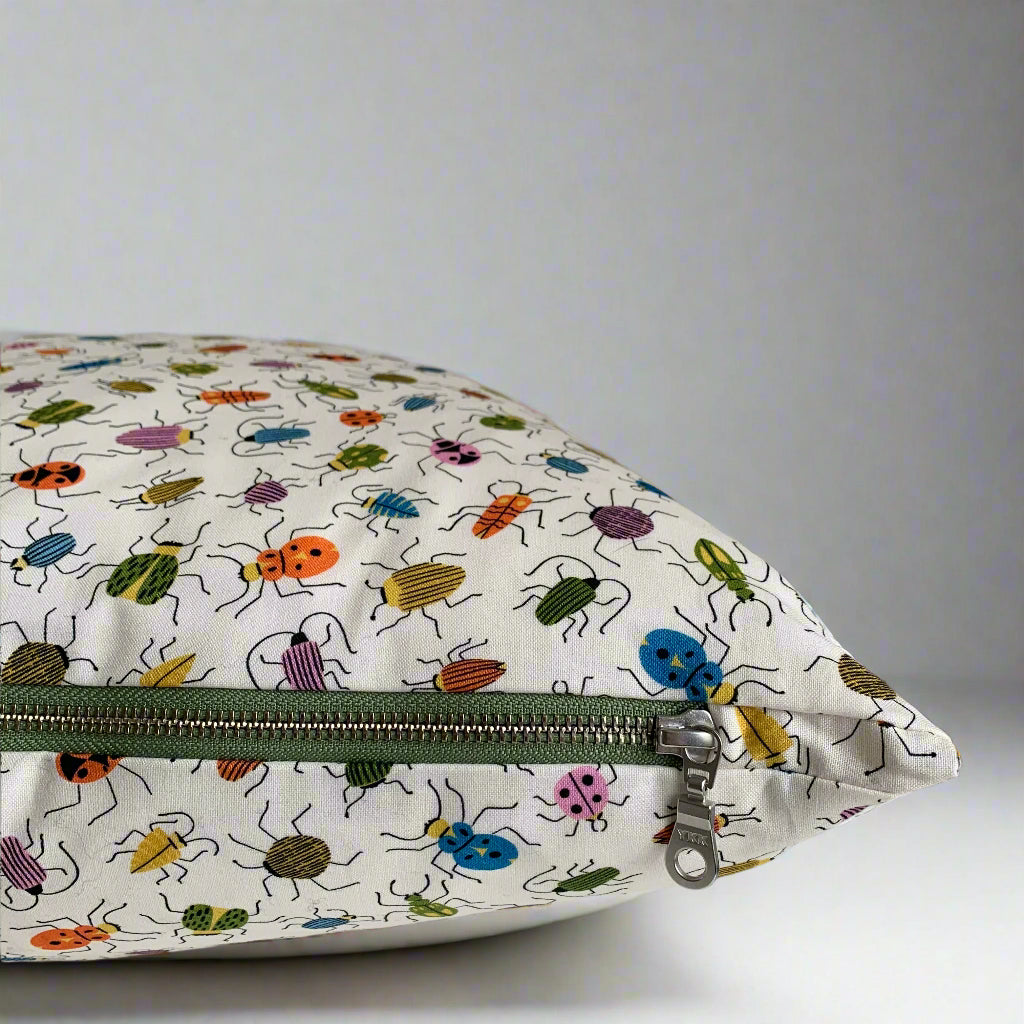 Handcrafted in Canada, this darling bug-patterned pillow is made from GOTS certified organic cotton. It's soft to the touch with an exposed green zipper adding a charming detail that complements the vibrant bugs and creamy backdrop. Bring a touch of playfulness and joy to your home, cottage, bunkie, or sunroom.