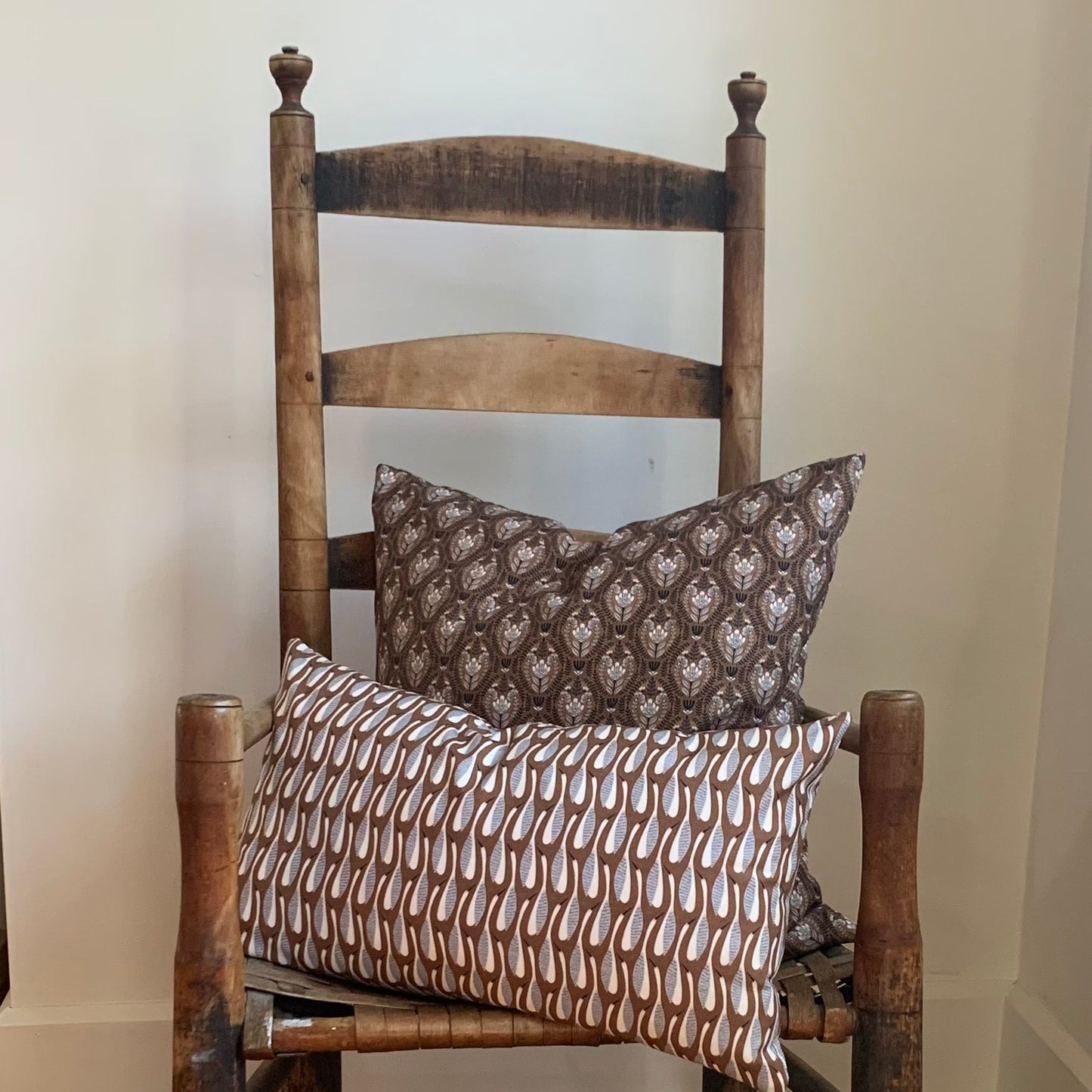 Wooden chair with organic cotton, navy, brown and cream patterned cushions .