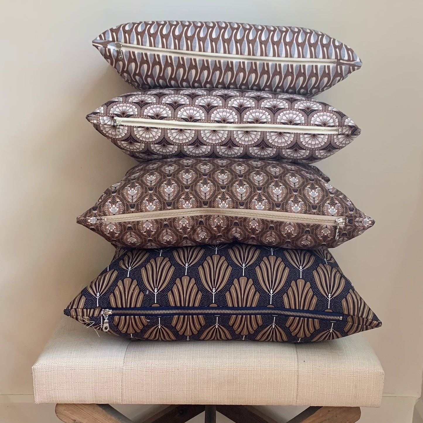 Organic cotton retro pattern pillows with exposed zipper. stacked on Linen stool.