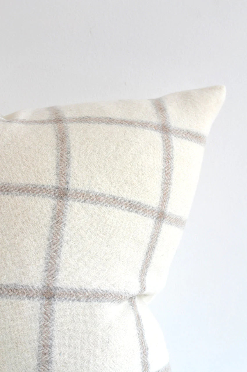This beautiful pillow is cozy and a show stopper with graphic checks on a white wool background.  The light tones make it a versatile option for any decor.  Made of 55% Alpaca 45% Wool Size: 22x22" Designed and made in Canada