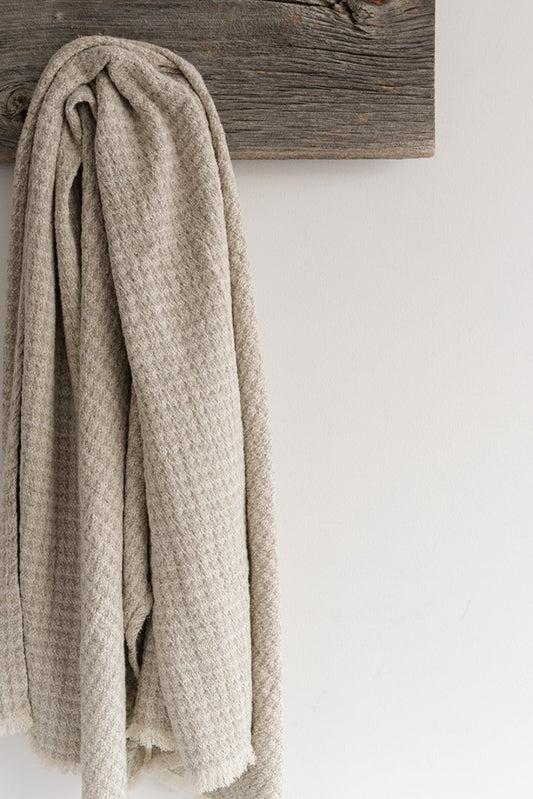 100% European linen throw has a subtle plaid texture with shades of natural and off white finished with hand-made fringes. 